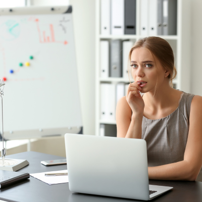 Woman contemplating at a desk.