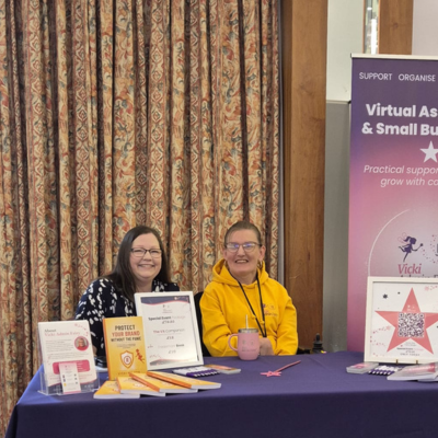 Two women at a promotional table.